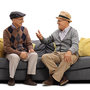 zwei ältere Männer sitzen auf einem Sofa und reden