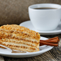 Geschmackvoller Honigkuchen mit Tasse Kaffee auf hölzernem Hintergrund.