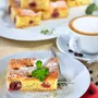 Frisch gebackener Kirschkuchen mit einer Tasse Cappuccino