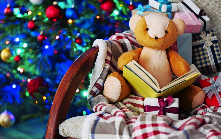 Teddy-Bär mit Buch und Geschenk-Boxen in Schaukelstuhl