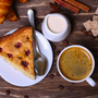 Tasse Kaffee mit Kuchen mit Cranberries und Croissants auf einem hölzernen Hintergrund